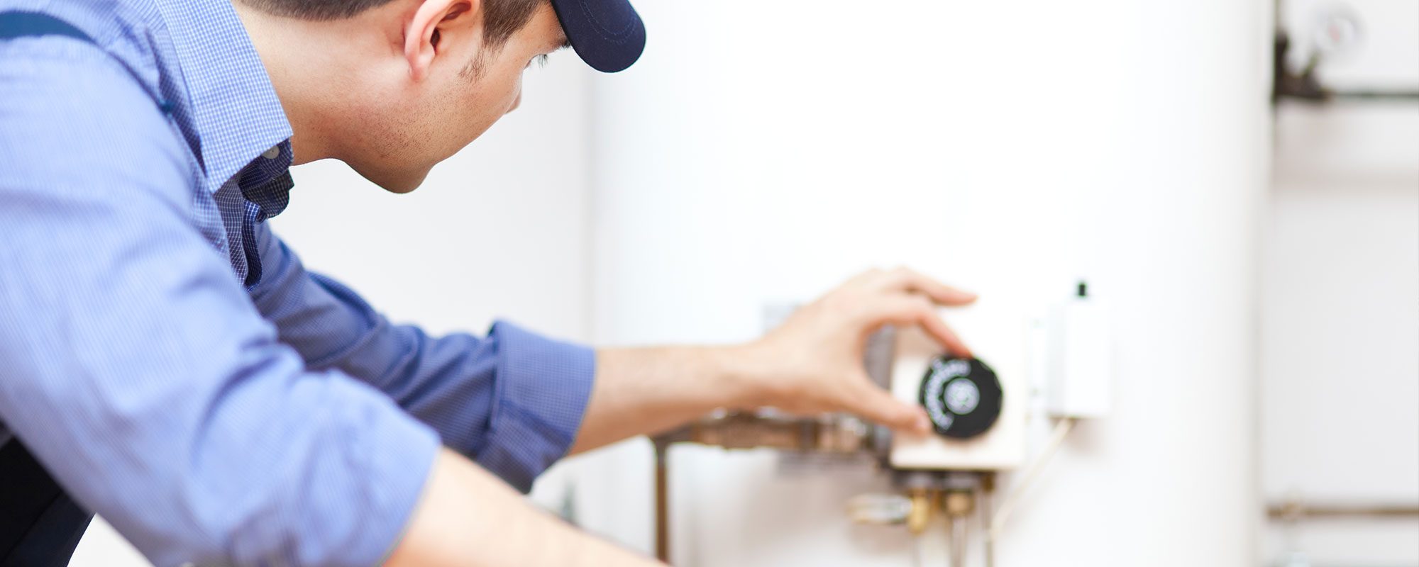 A man working on a water heater representing the water heater services by John J. Cahill servicing Chicago, IL